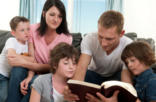 familia llegint i pregant