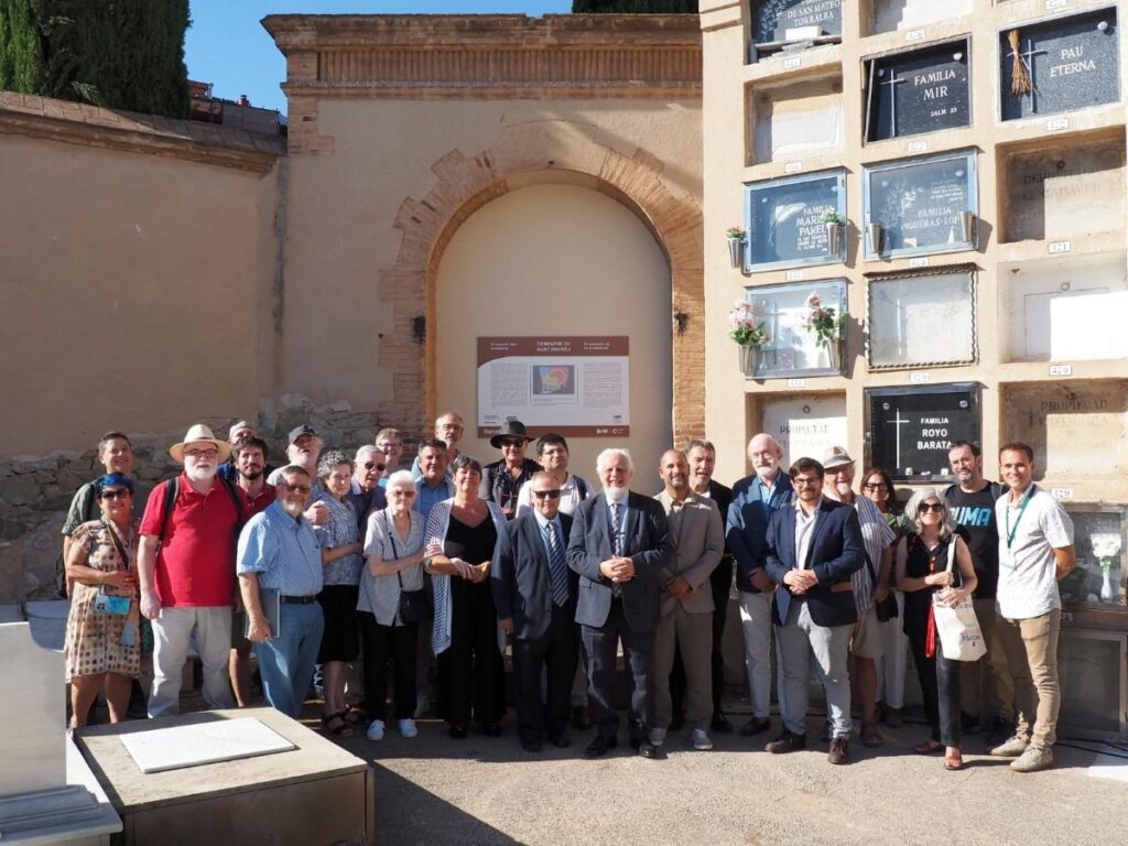 Foto de grup dels participants a l’acte de recuperació de la memòria dels cementiris protestants de Barcelona, davant la porta tapiada del recinte protestant del Cementiri de Sant Andreu