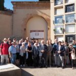 Foto de grup dels participants a l’acte de recuperació de la memòria dels cementiris protestants de Barcelona, davant la porta tapiada del recinte protestant del Cementiri de Sant Andreu
