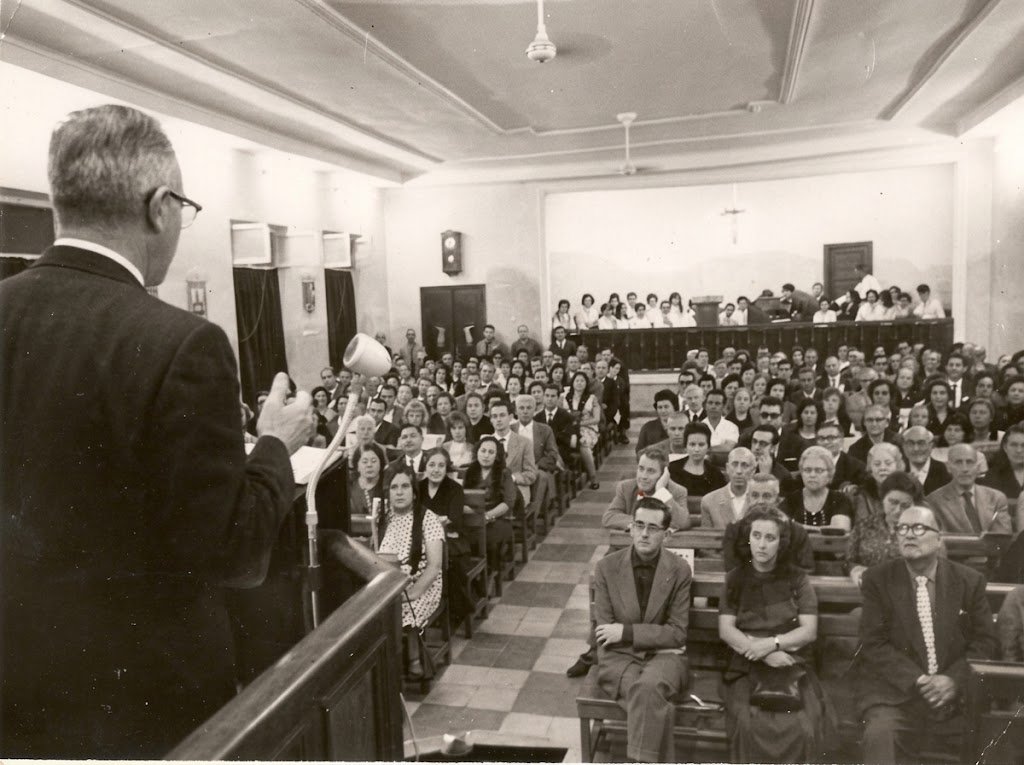 Pastor evangèlic predicant davant una congregació plena durant els anys del franquisme (fotografia històrica)
